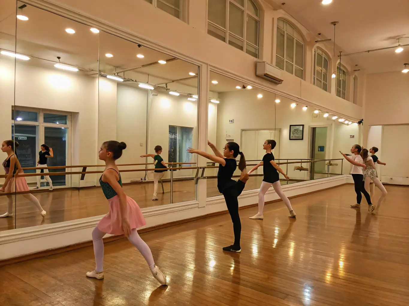 A vibrant photo capturing a community ballet workshop in session, with participants of various ages and skill levels engaged in a dance exercise, led by an instructor. The setting is a bright, open studio with ballet barres and mirrors.